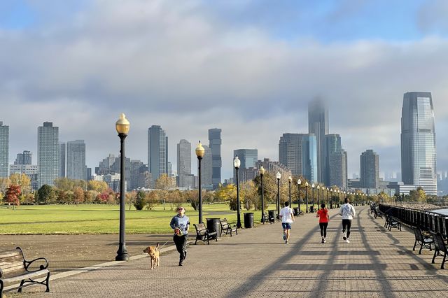 People go for walk at New Jersey's Liberty State Park on a cloudy day in New York City.